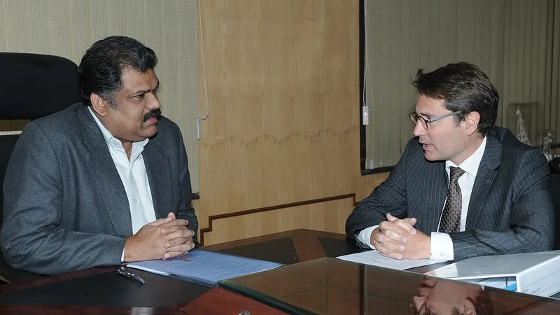 Two professionals discussing documents at a meeting table