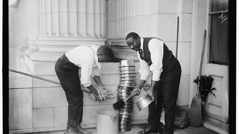 Historic monochrome photograph of workers cleaning metal household items