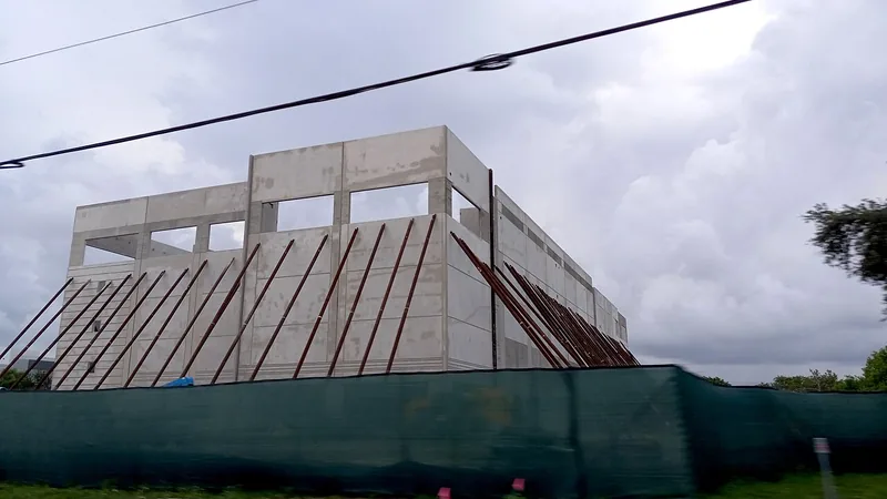 Building under construction behind a perimeter fence