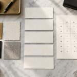 Blank business name cards beside a structured comparison grid and premium material samples